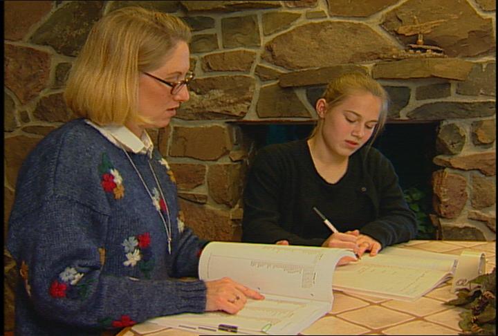 Mother giving her daughter a Spelling Power test